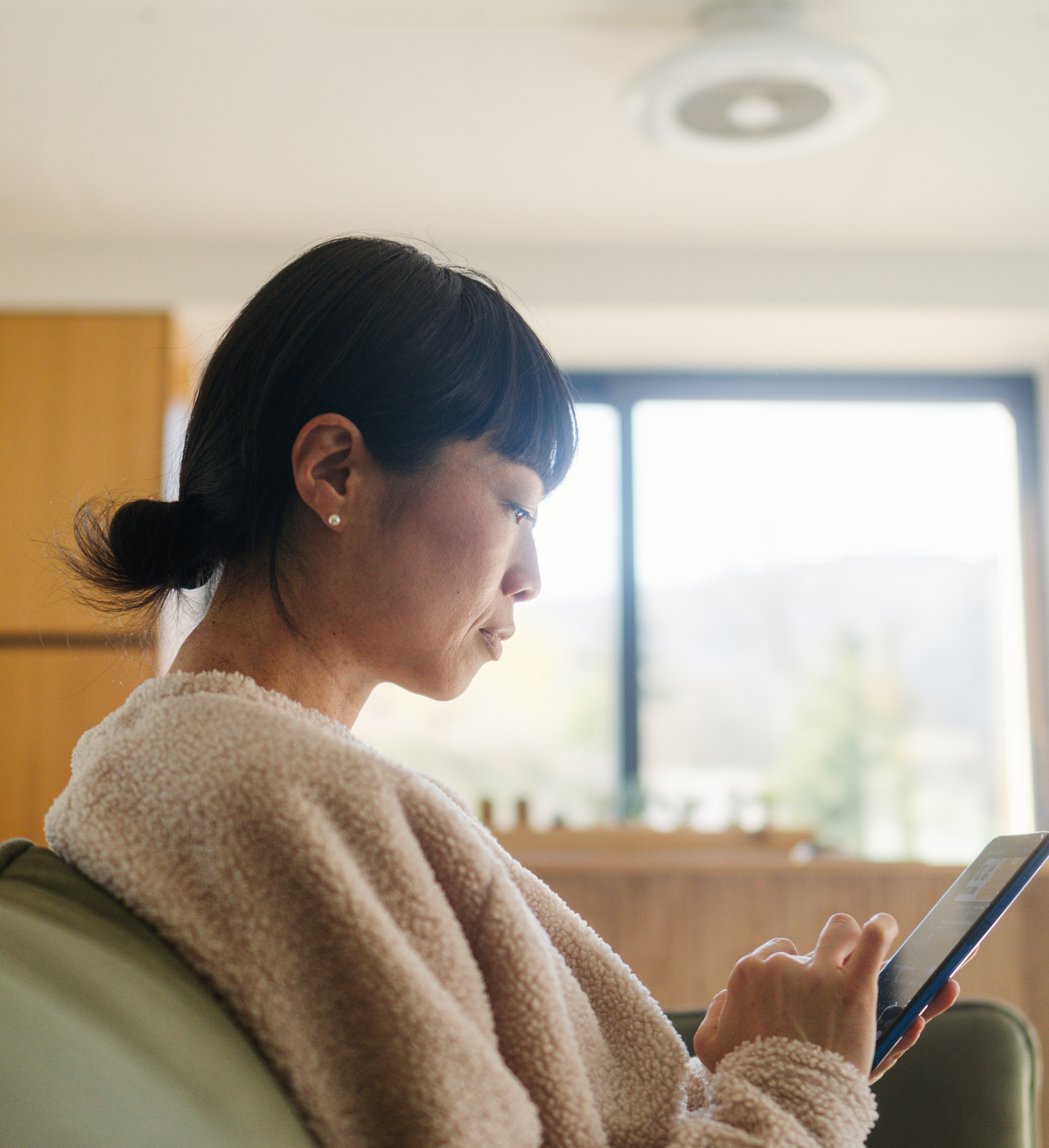 Young woman sitting down and scrolling on her phone