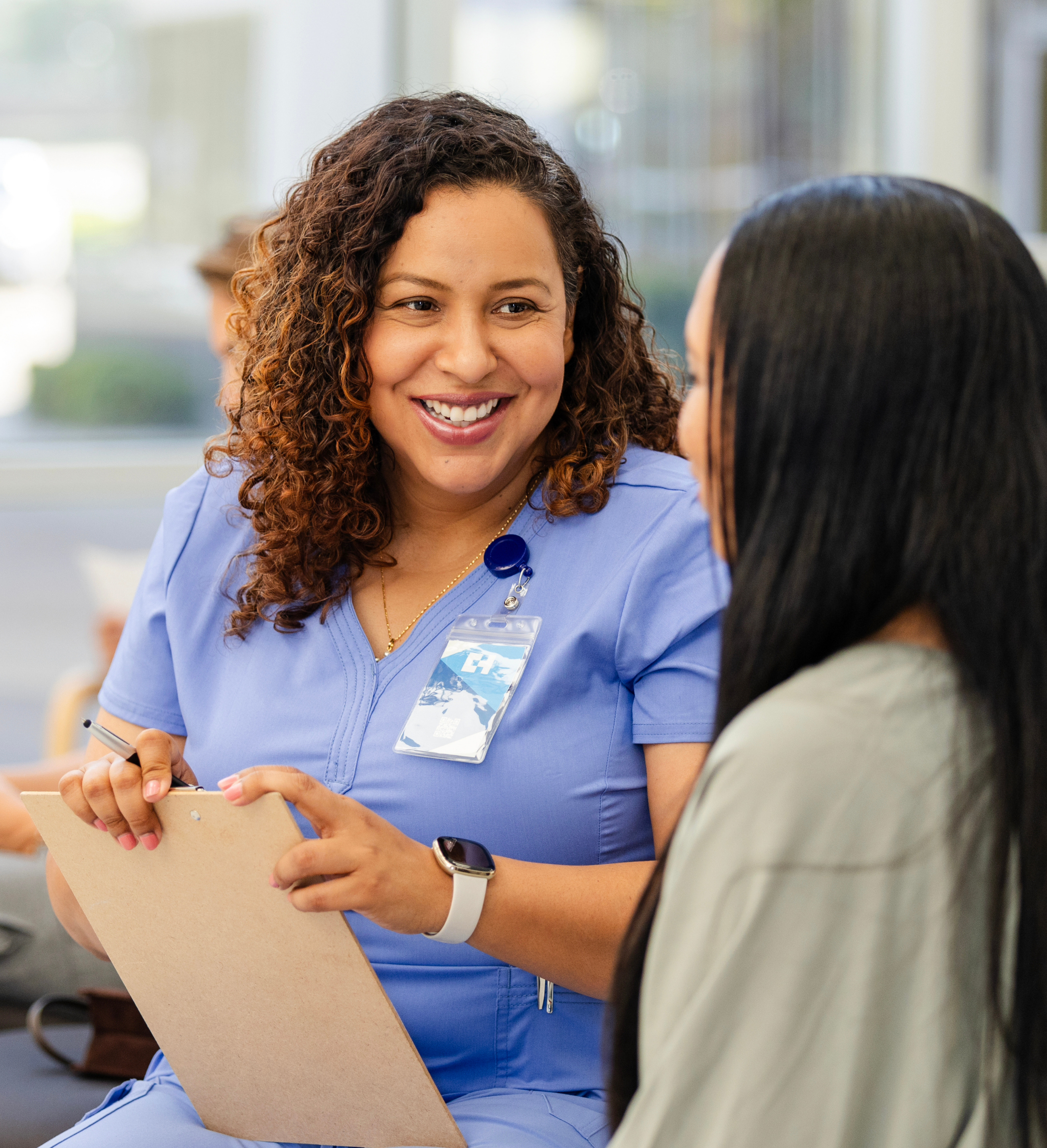Female doctor with clipboard talking to a female patient